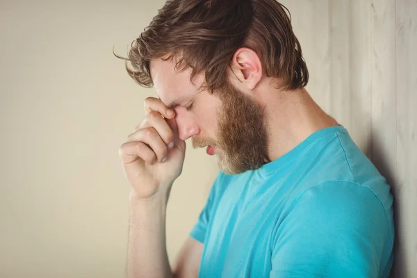 Troubled hipster leaning against wall — Stock Photo, Image