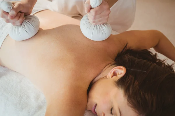 Frau bekommt Kräuterkompresse-Massage — Stockfoto