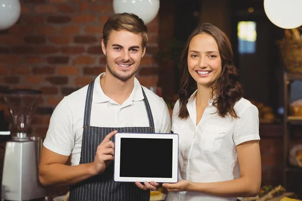 Colaboradores sonrientes mostrando una tableta — Foto de Stock