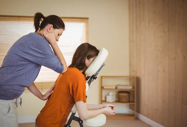 Jonge vrouw krijgen massage in stoel — Stockfoto