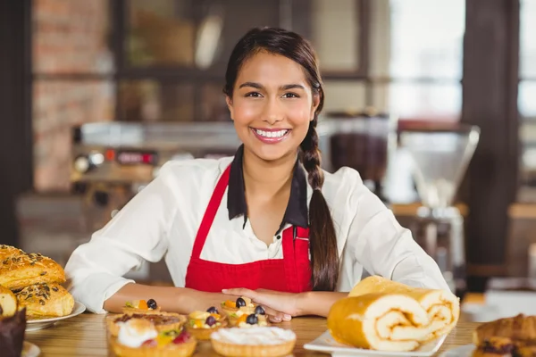 Cameriera sorridente in piedi sopra pasticcini — Foto Stock