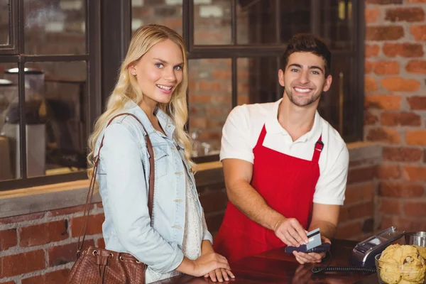 Smiling waiter swiping the credit card — Stock Photo, Image