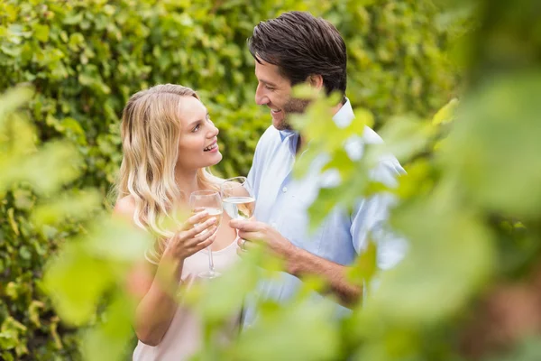 Junges glückliches Paar lächelt einander an und stößt an — Stockfoto