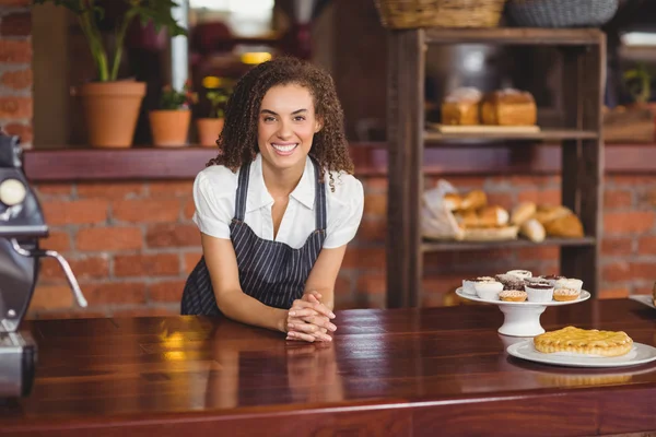 Barista sonriente apoyado en el mostrador — Foto de Stock