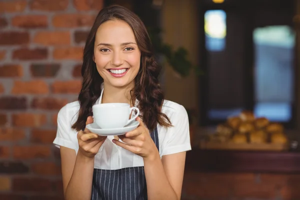 Krásná servírka nabízí šálek kávy — Stock fotografie