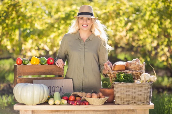 Blonde glimlachend boven een tafel van biologisch voedsel — Stockfoto