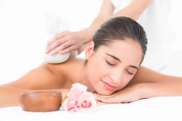 Brunette genieten van kruiden comprimeren massage — Stockfoto