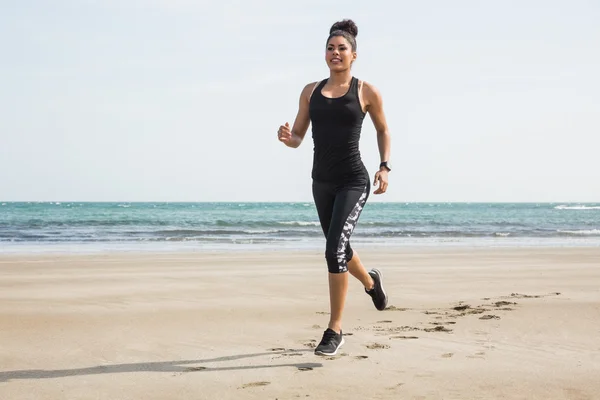 Fitte Frau beim Joggen im Sand — Stockfoto