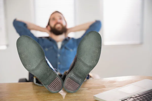 Hipster businessman relaxing at his desk Stock Picture