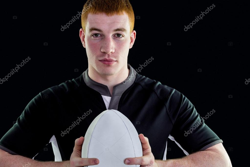 Jogador de rugby segurando uma bola de rugby