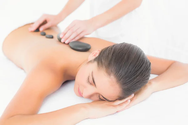 Brunette enjoying a hot stone massage — Stock Photo, Image