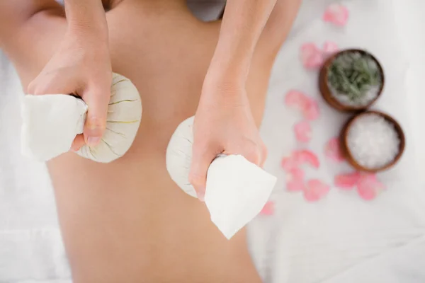 Woman enjoying herbal compress massage — Stock Photo, Image