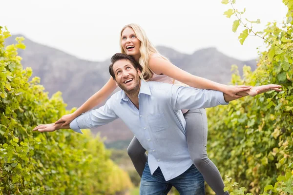 Gelukkig jongeman met gelukkig vrouw op zijn rug — Stockfoto