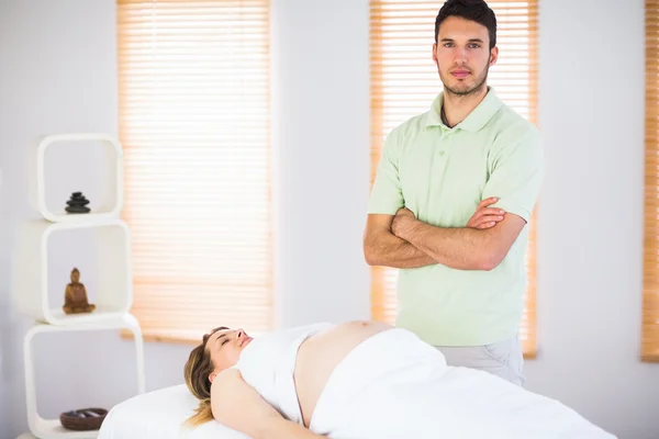 Portrait of masseur standing behind his pregnant patient — Stockfoto