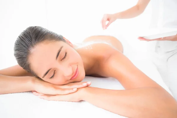 Brunette enjoying a salt scrub treatment — Stock Photo, Image