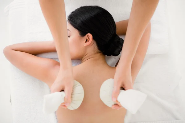 Vrouw genieten van kruiden comprimeren massage — Stockfoto