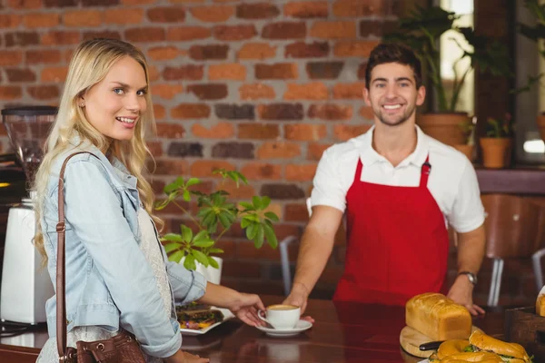 Uśmiechnięty barista serwuje klienta — Zdjęcie stockowe