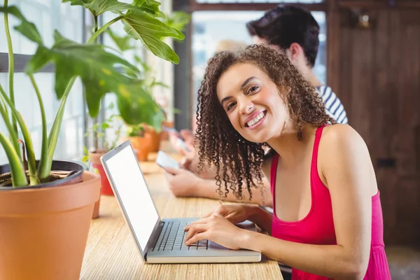 Femeia zâmbitoare tastând pe un laptop — Fotografie, imagine de stoc