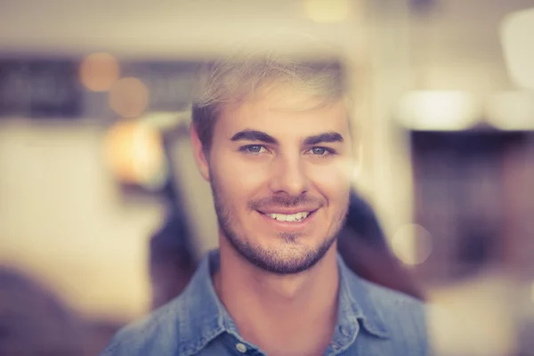 Smiling hipster looking through window — Stock Photo, Image