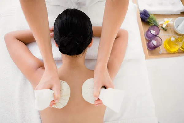 Kvinna som njuter av växtbaserade compress massage — Stockfoto