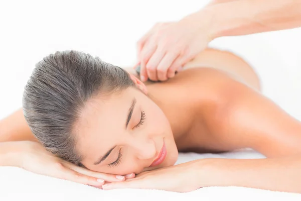 Brunette enjoying a hot stone massage — Stock Photo, Image