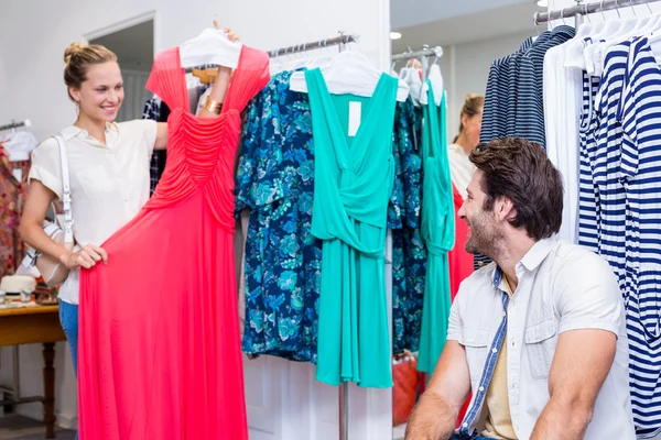 Woman showing red dress to boyfriend — Stock Photo, Image