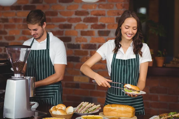 Mooie serveerster plukken een sandwich — Stockfoto