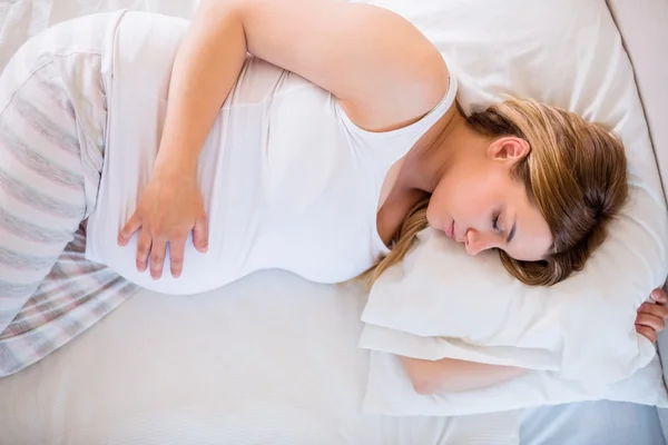 Pregnant woman sleeping on bed — Stock Photo, Image