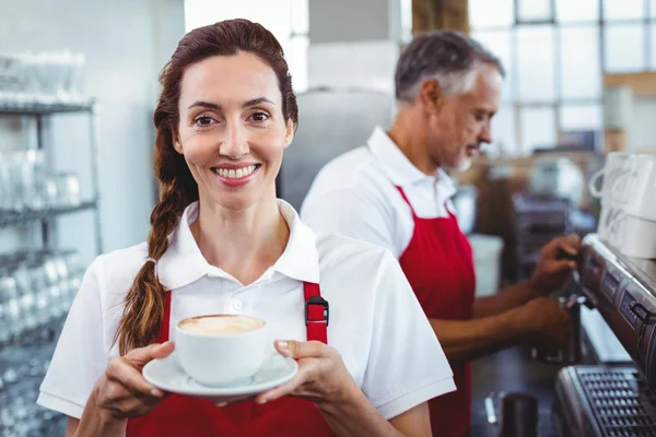 Leende barista holding kopp kaffe — Stockfoto