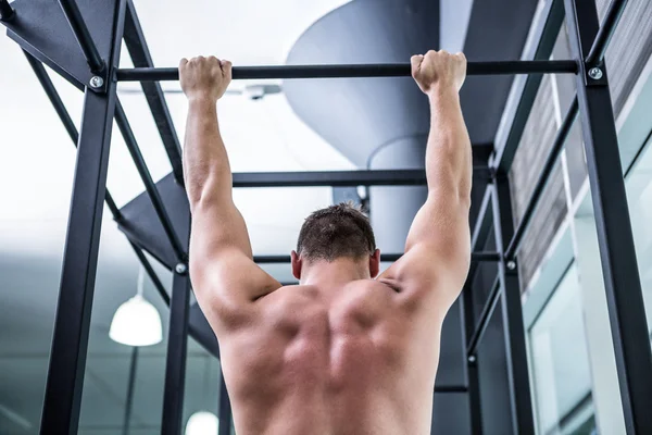 Back view of muscular man doing pull ups — Stock Photo, Image