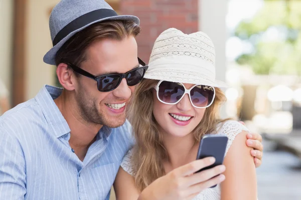 Cute couple looking at their smartphone — Stock Photo, Image