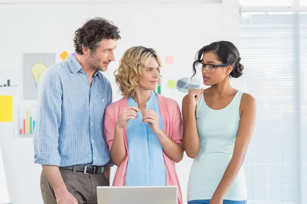 Casual business team looking at laptop together — Stock Photo, Image