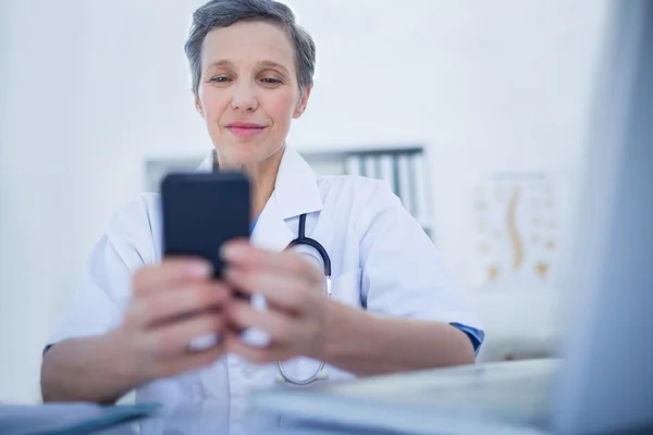 Zufriedene Ärztin mit ihrem Smartphone — Stockfoto