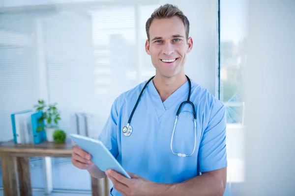 Médico sonriente sosteniendo su comprimido —  Fotos de Stock