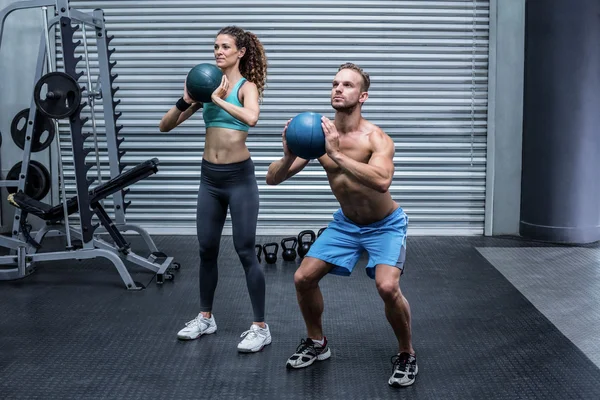 Casal muscular fazendo exercício de bola — Fotografia de Stock