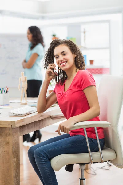 Mujer de negocios llamando a alguien en su escritorio —  Fotos de Stock