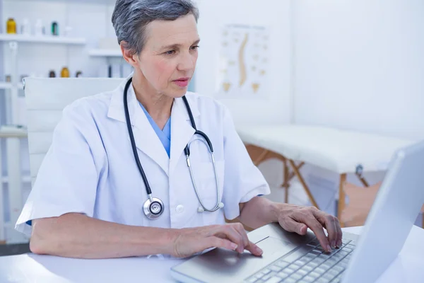 Médico femenino serio usando su computadora portátil — Foto de Stock