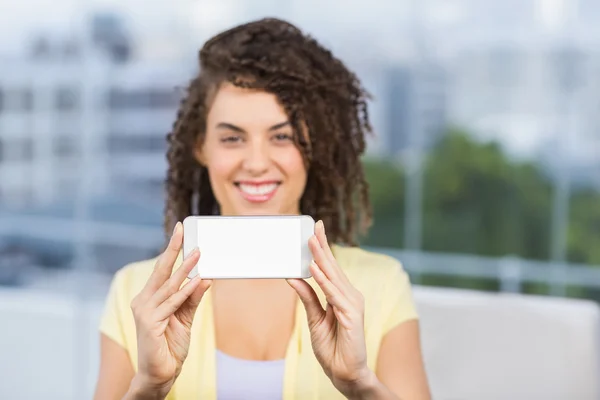 Usměvavá moderátorka ukazující její telefon — Stock fotografie