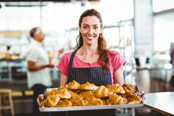 Bäcker zeigt Tablett mit frischem Croissant — Stockfoto