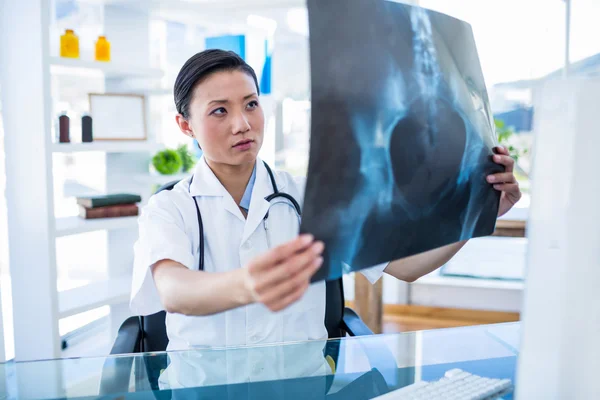 Concentrated doctor analyzing X-rays — Stock Photo, Image