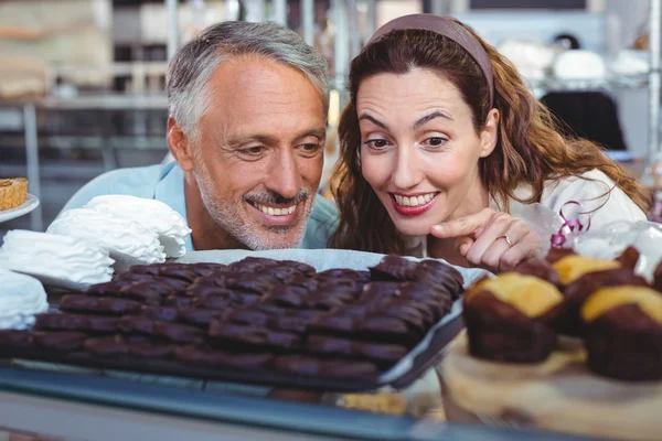 Pareja feliz señalando pasteles — Foto de Stock