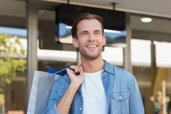 Un hombre sonriente con bolsas de compras — Foto de Stock
