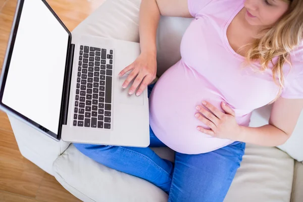 Беременная женщина пользуется ноутбуком — стоковое фото