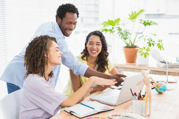 Felices compañeros de trabajo usando portátil en el escritorio — Foto de Stock