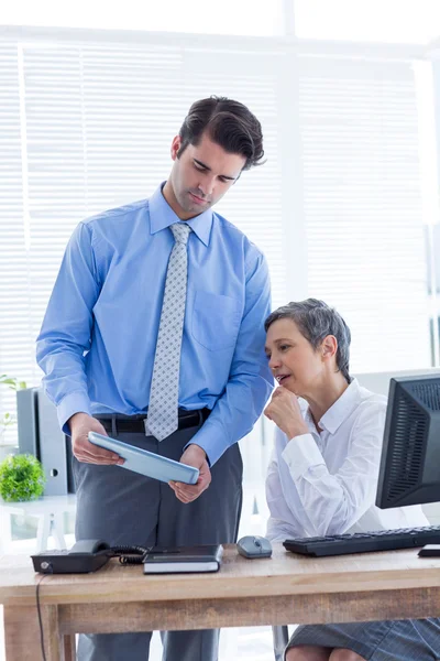 Colegas serios trabajando juntos en la tableta — Foto de Stock