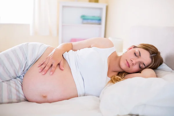 Mujer embarazada durmiendo en la cama — Foto de Stock