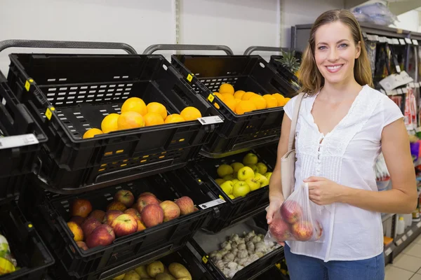 Sorridente bella donna bionda che compra mele — Foto Stock