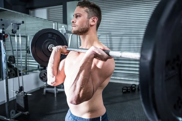 Uomo muscolare che solleva un bilanciere — Foto Stock