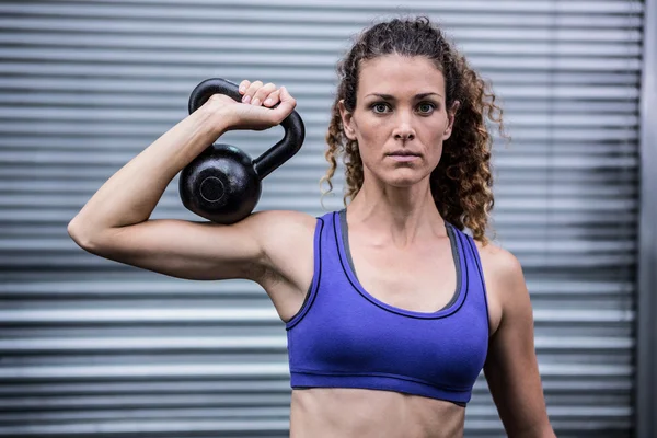 Portret van gespierde vrouw uitoefenend met kettlebell — Stockfoto