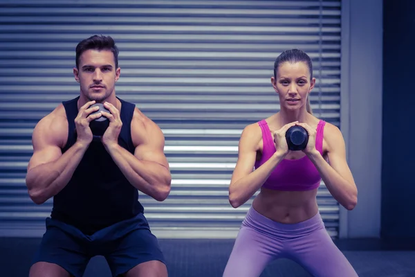 Couple musclé faisant de l'exercice avec des kettlebells — Photo